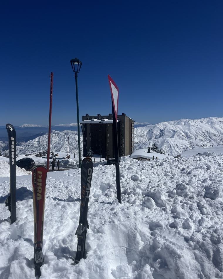 Esquis fincados na neve no topo da montanha