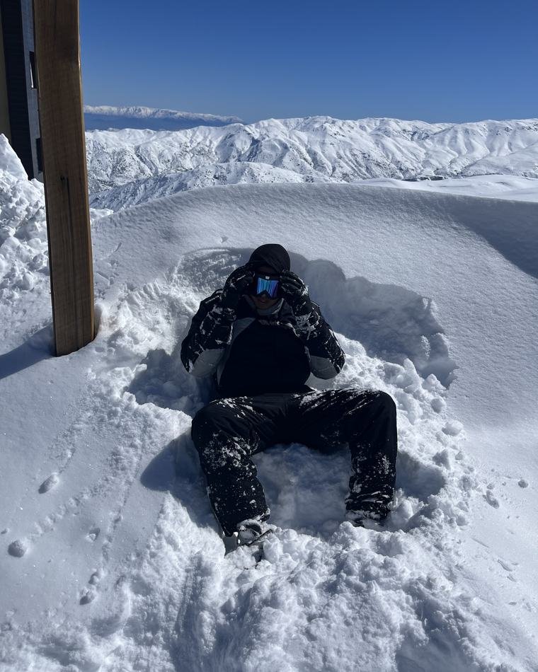 Membro do Club na neve com a cordilheira ao fundo